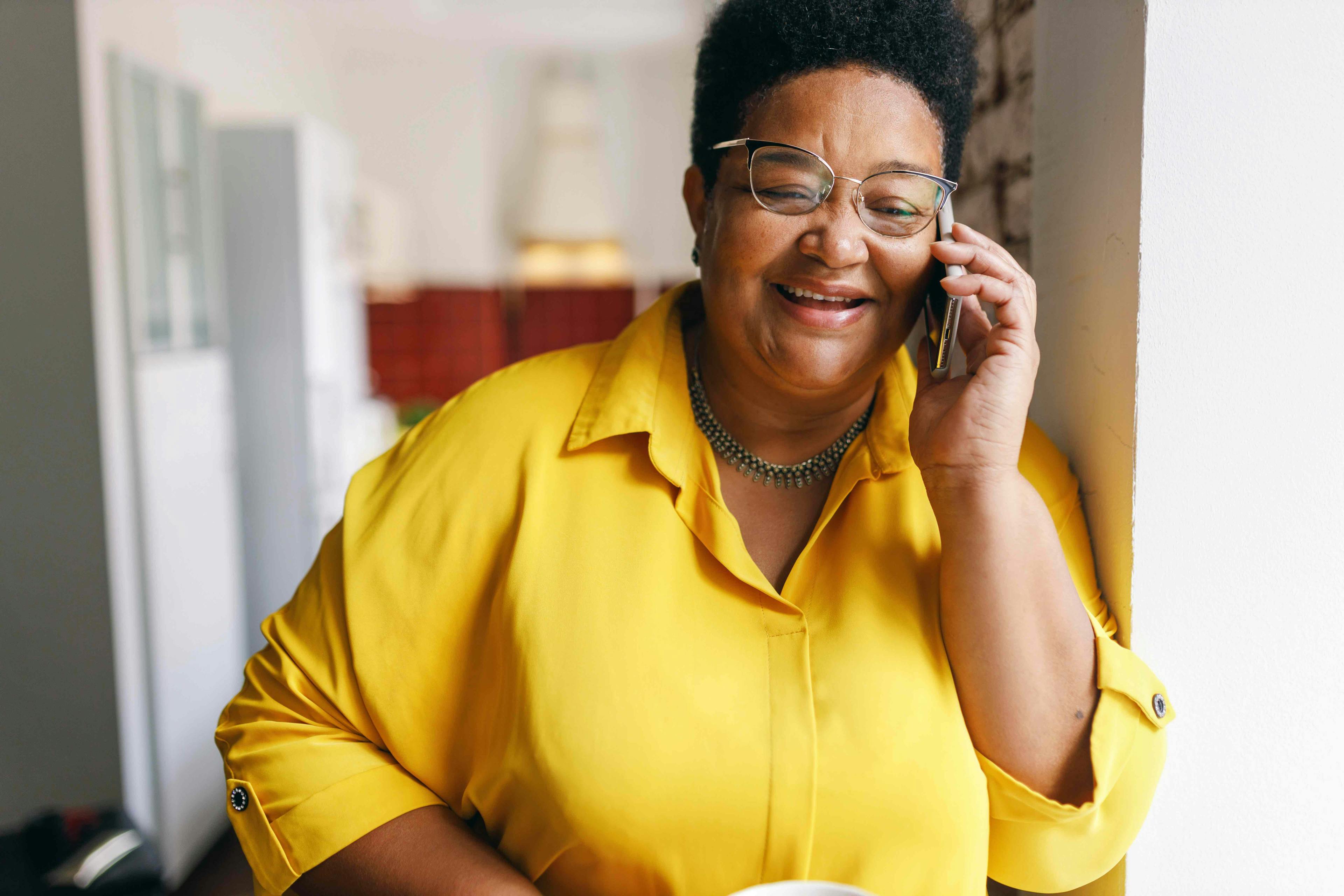 Woman holding a cup of coffee and talking on the phone
