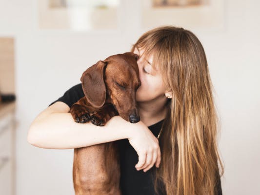 Femme qui embrasse son chien