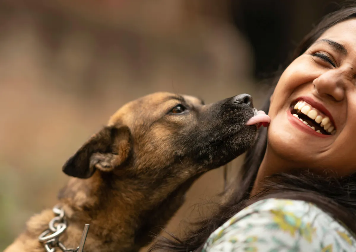 chien qui lèche le coup de sa maitresse, elle rigole
