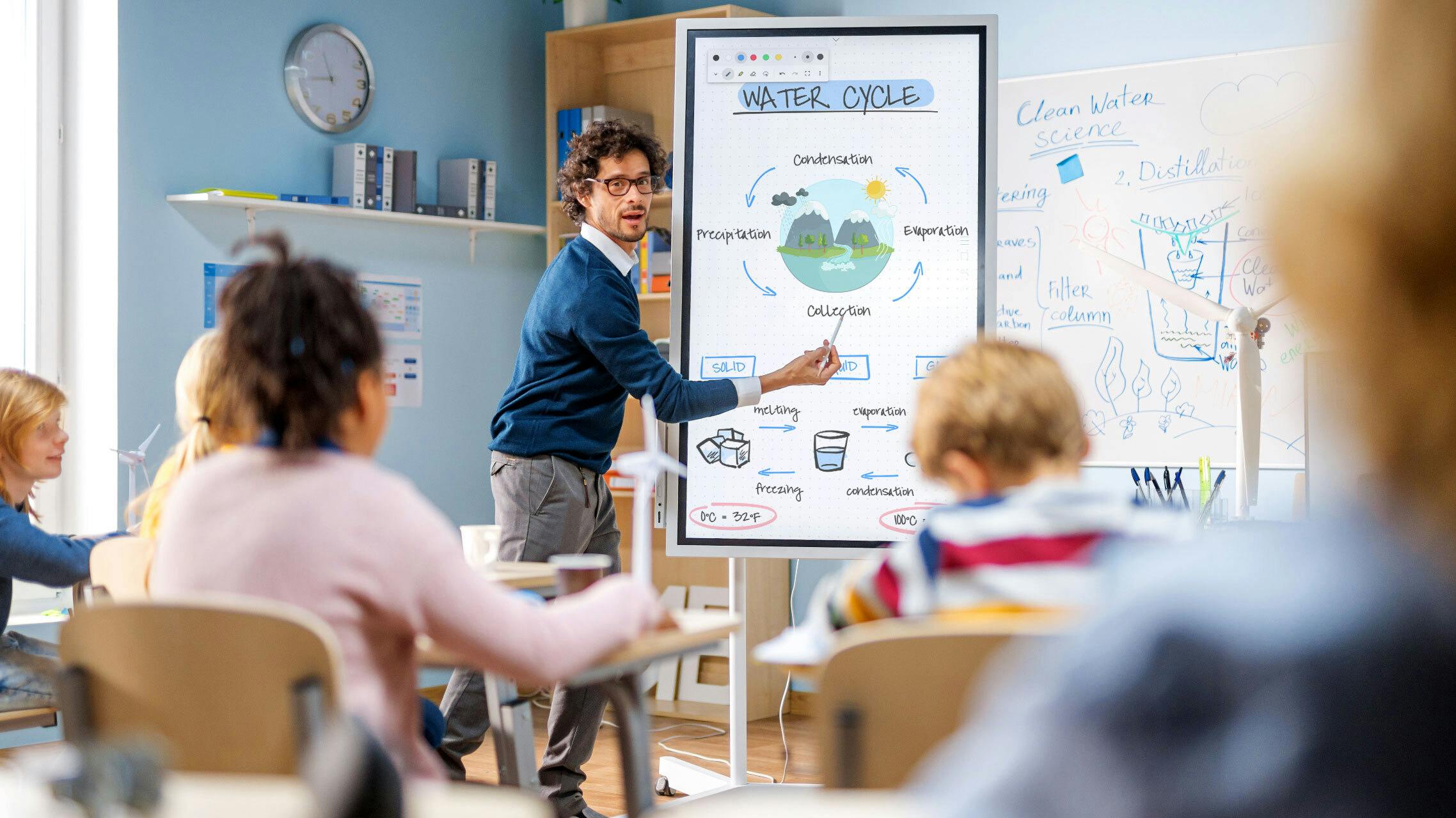 Classroom with a teacher using an interactive whiteboard to explain concepts to students