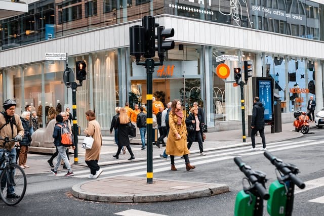 People walking in front of a retail store in the street