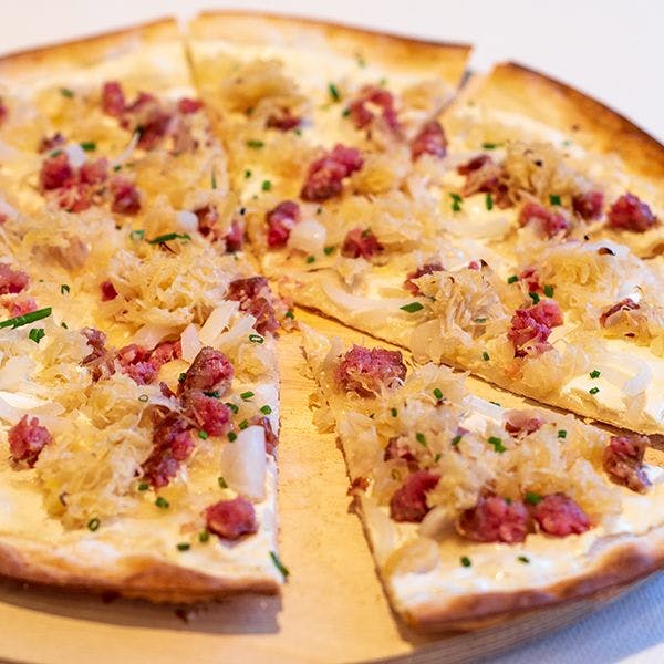 Flammkuchen con cipolle, crauti e Saucisson