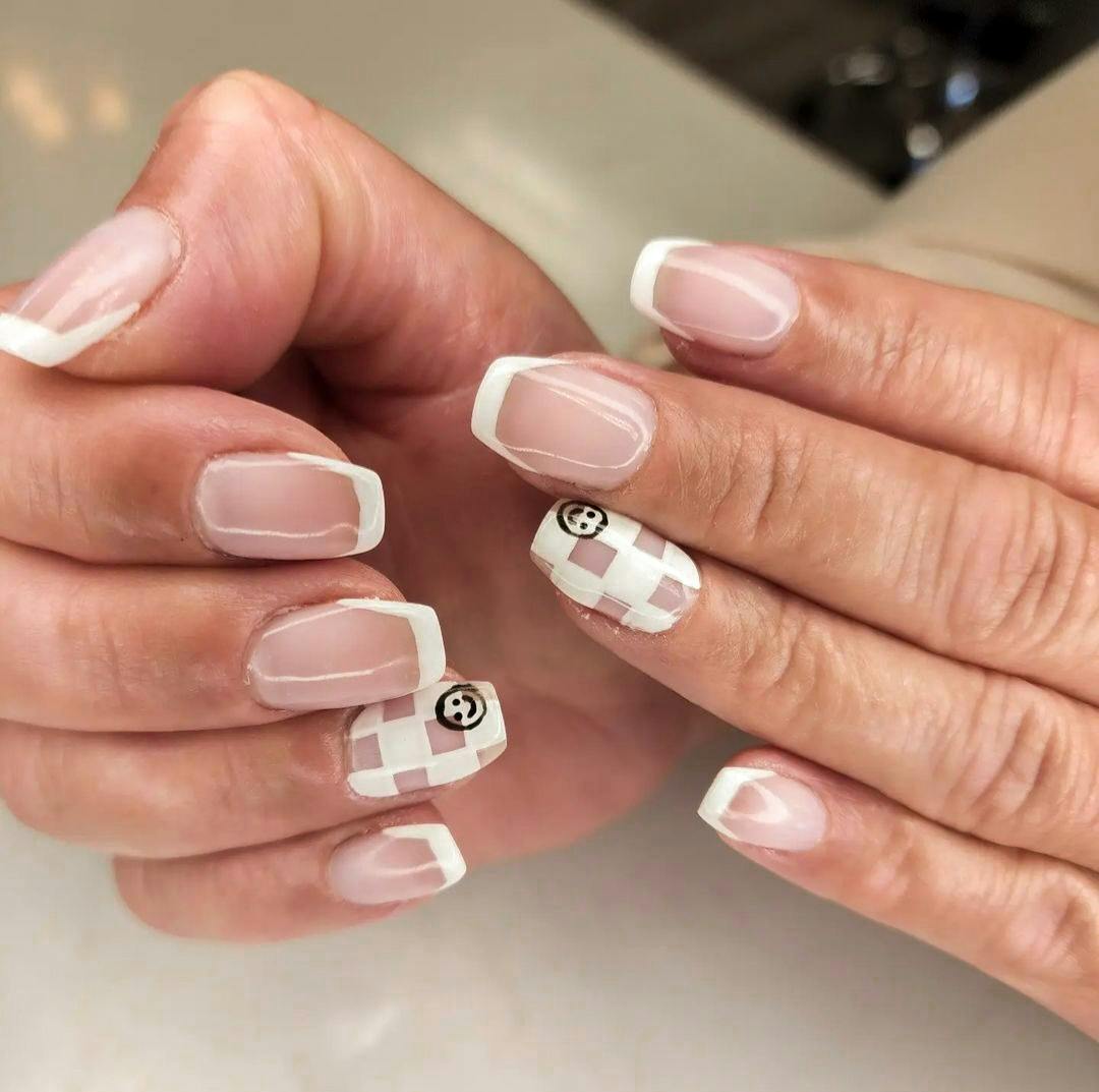 Manicured nails with pink checkered smiley pattern