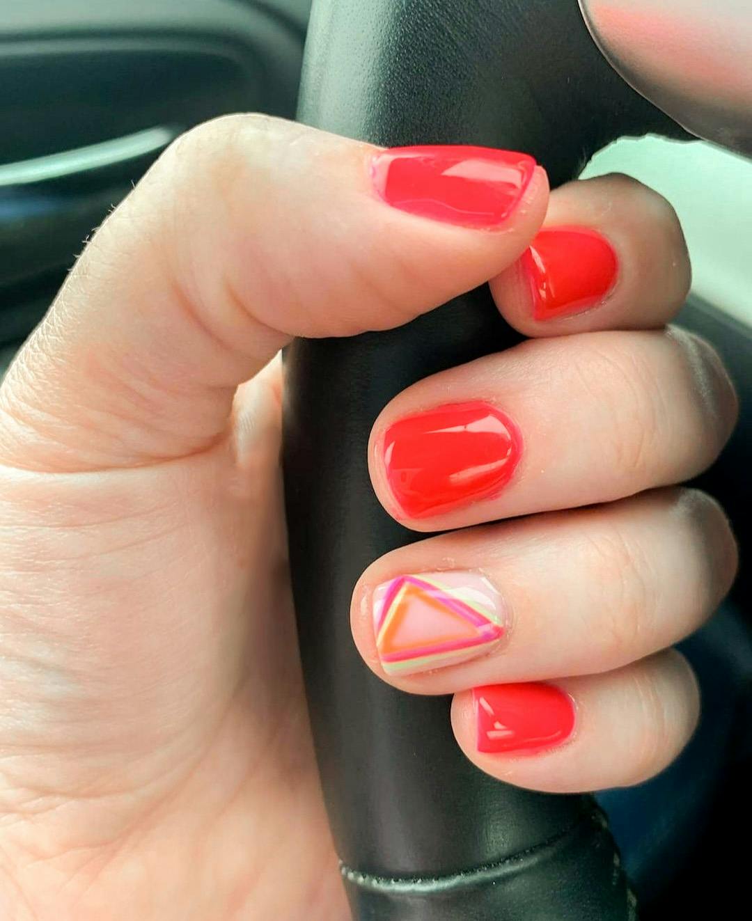 Hands painted red with triangle pattern on one nail