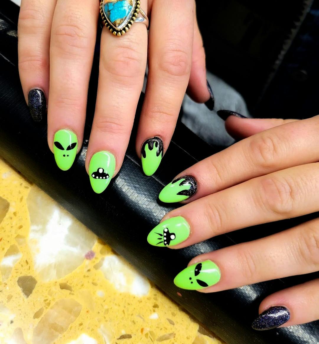 Hands on table painted wih bright green aliens
