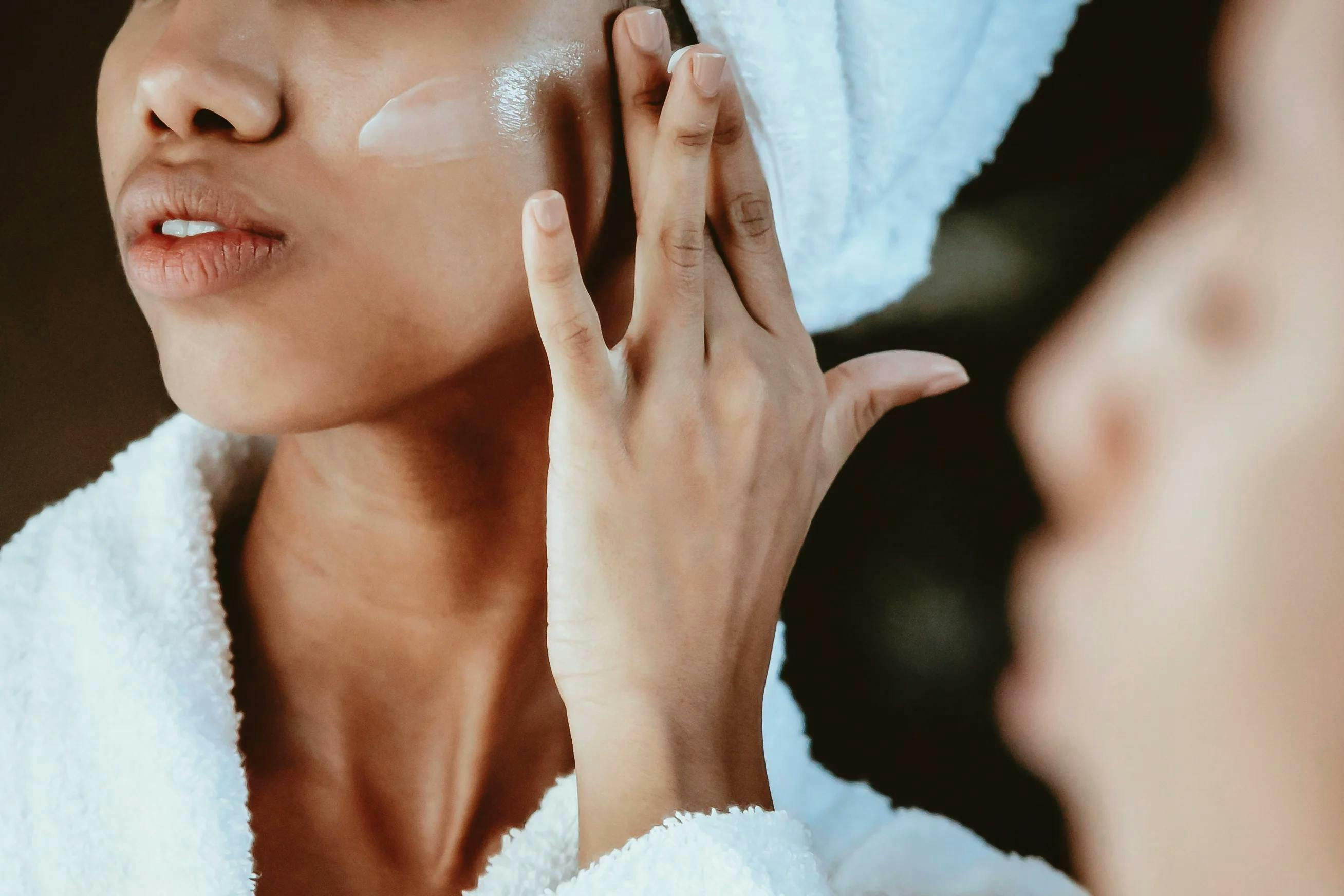 Lady applying skin care on her cheek