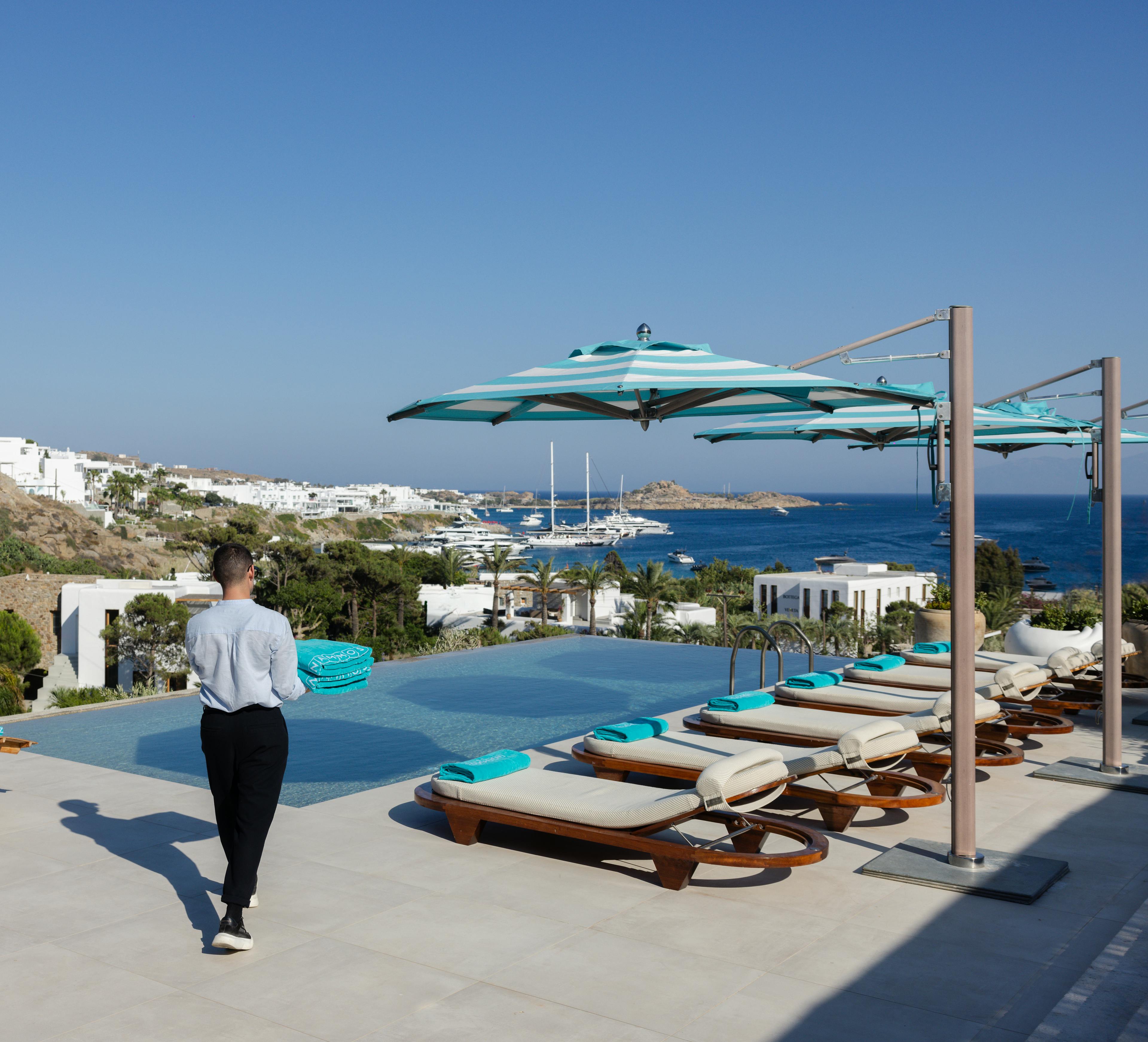 Butler servicing private pool and sunbeds at Nammos villas