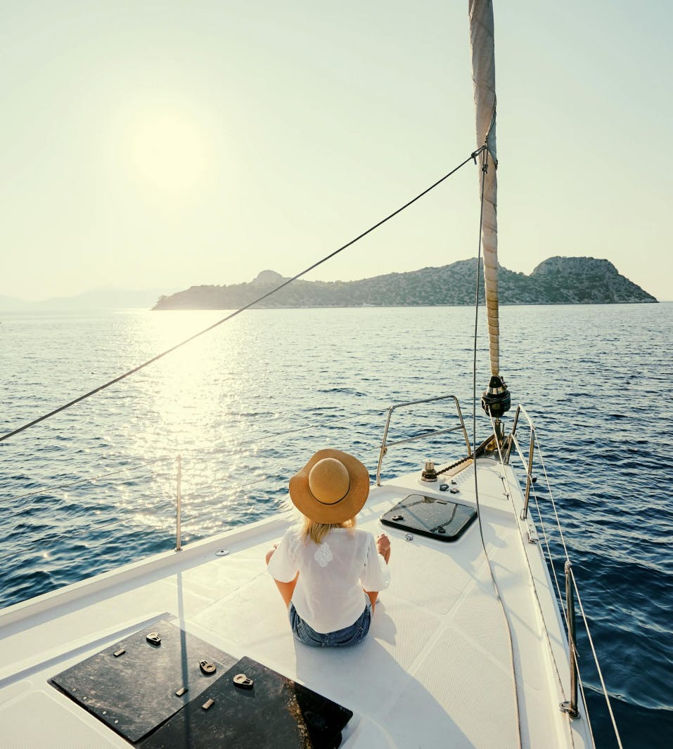 Lady wearing a hat sitting on boat in the Aegean Sea 