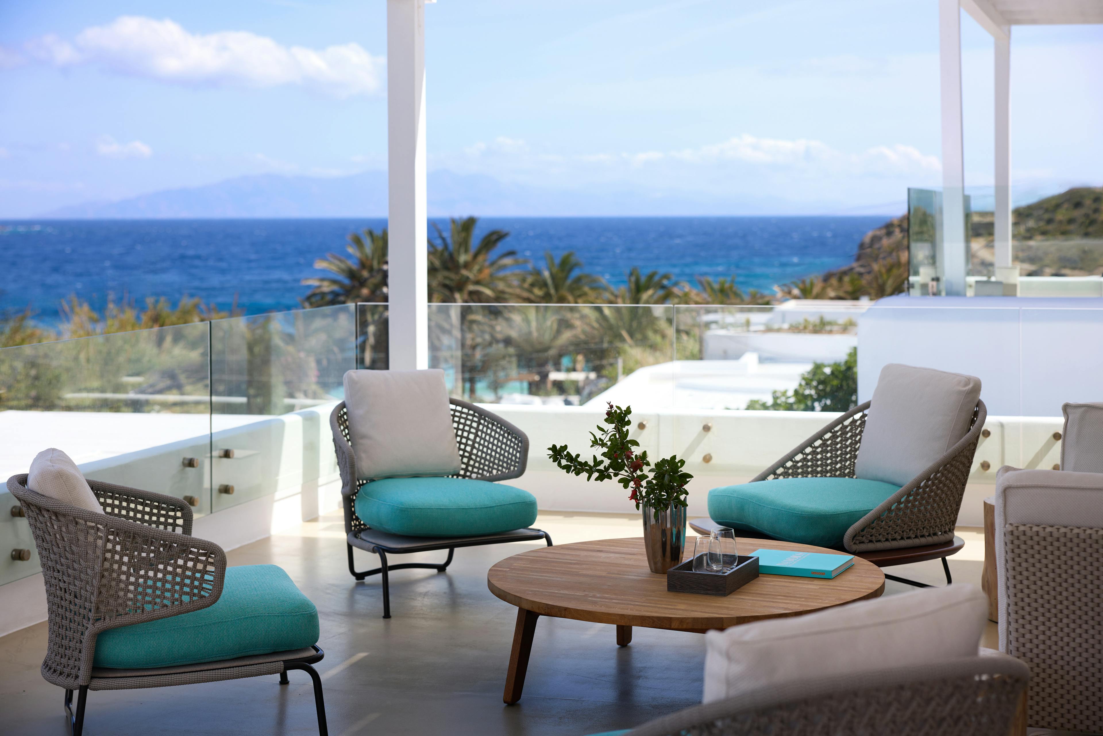 Four armchairs and a table on the terrace overlooking the Aegean Sea