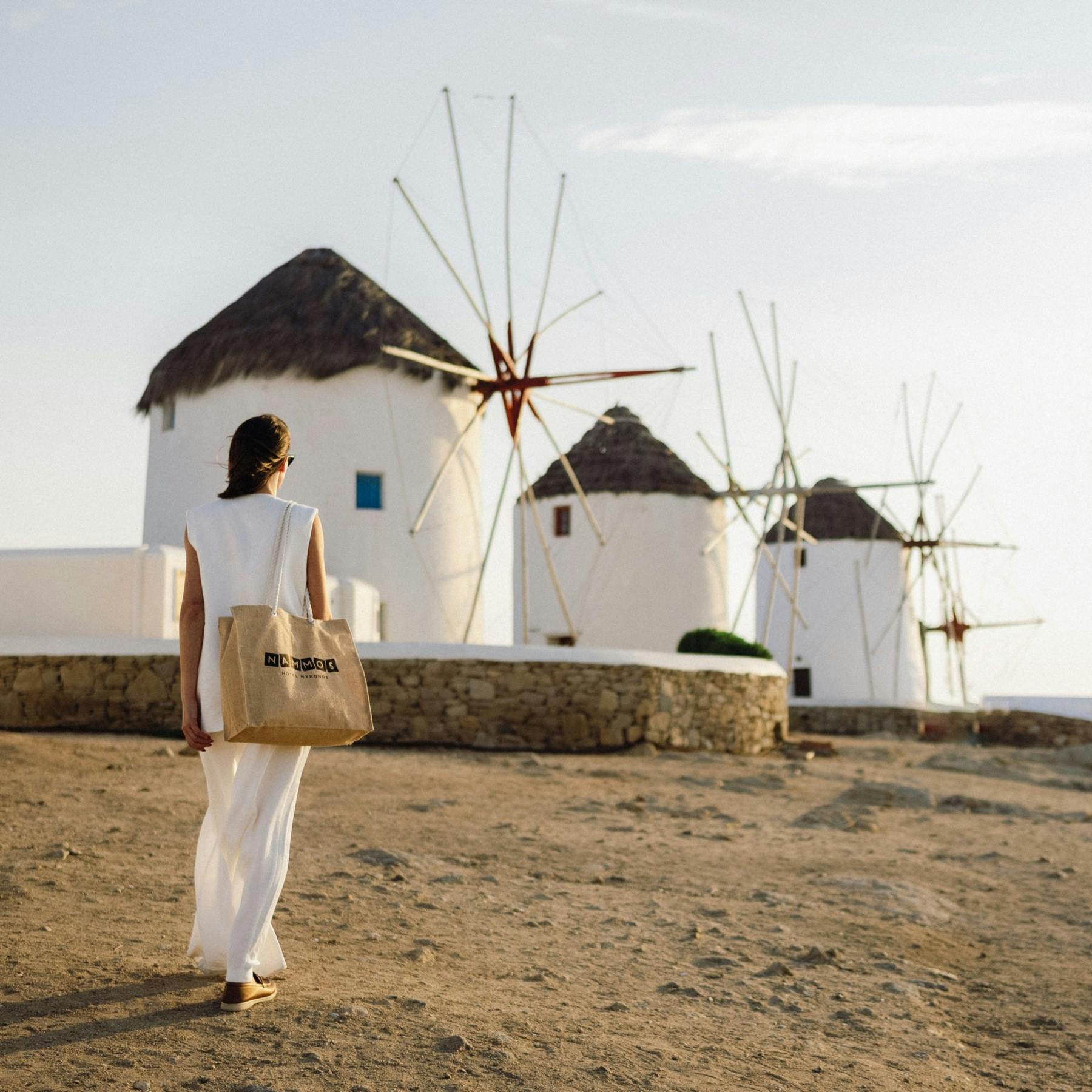 Lady walking with Nammos handbag towards the Mykonos windmills 