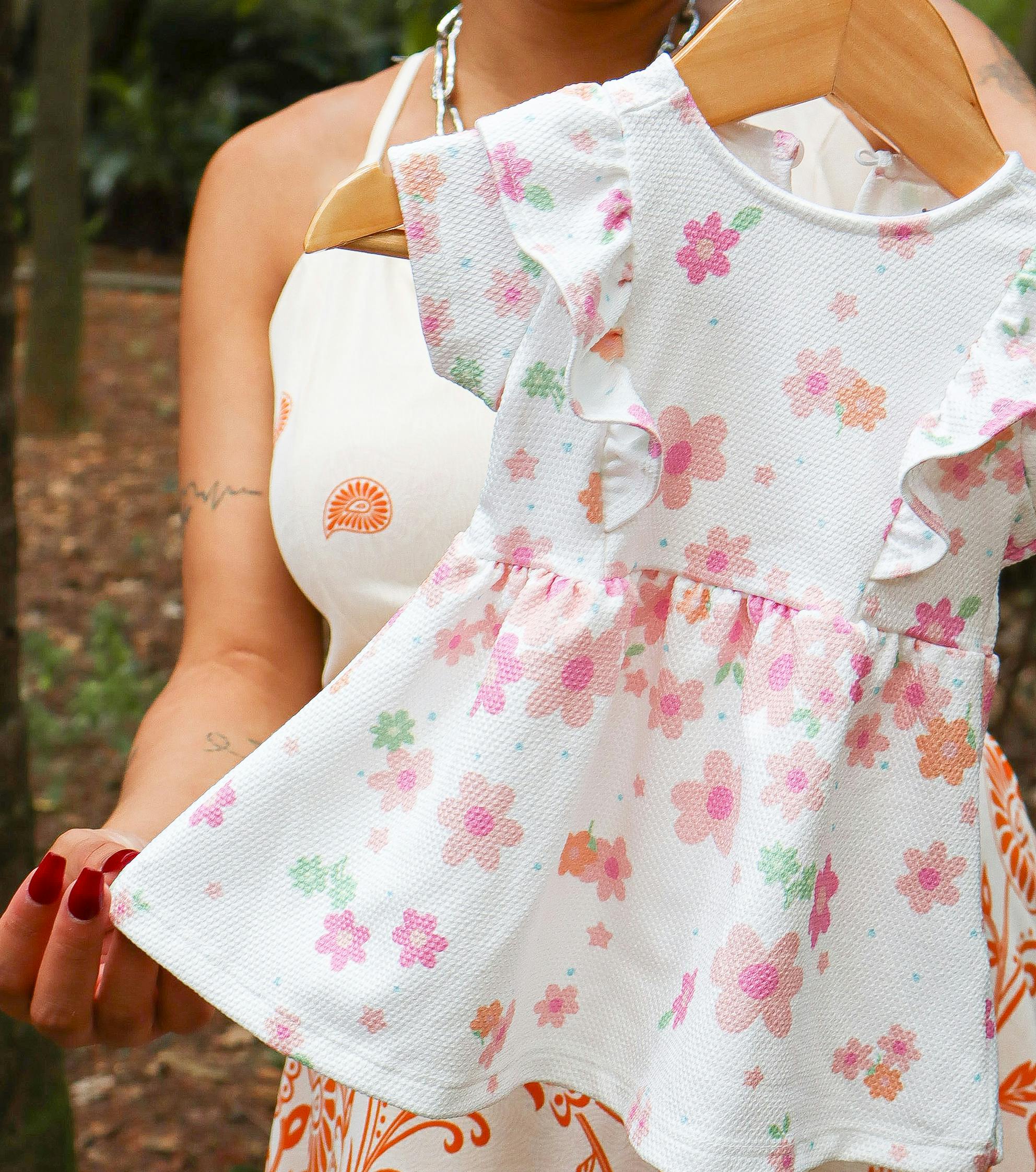 Mãe segurando roupas da futura filha