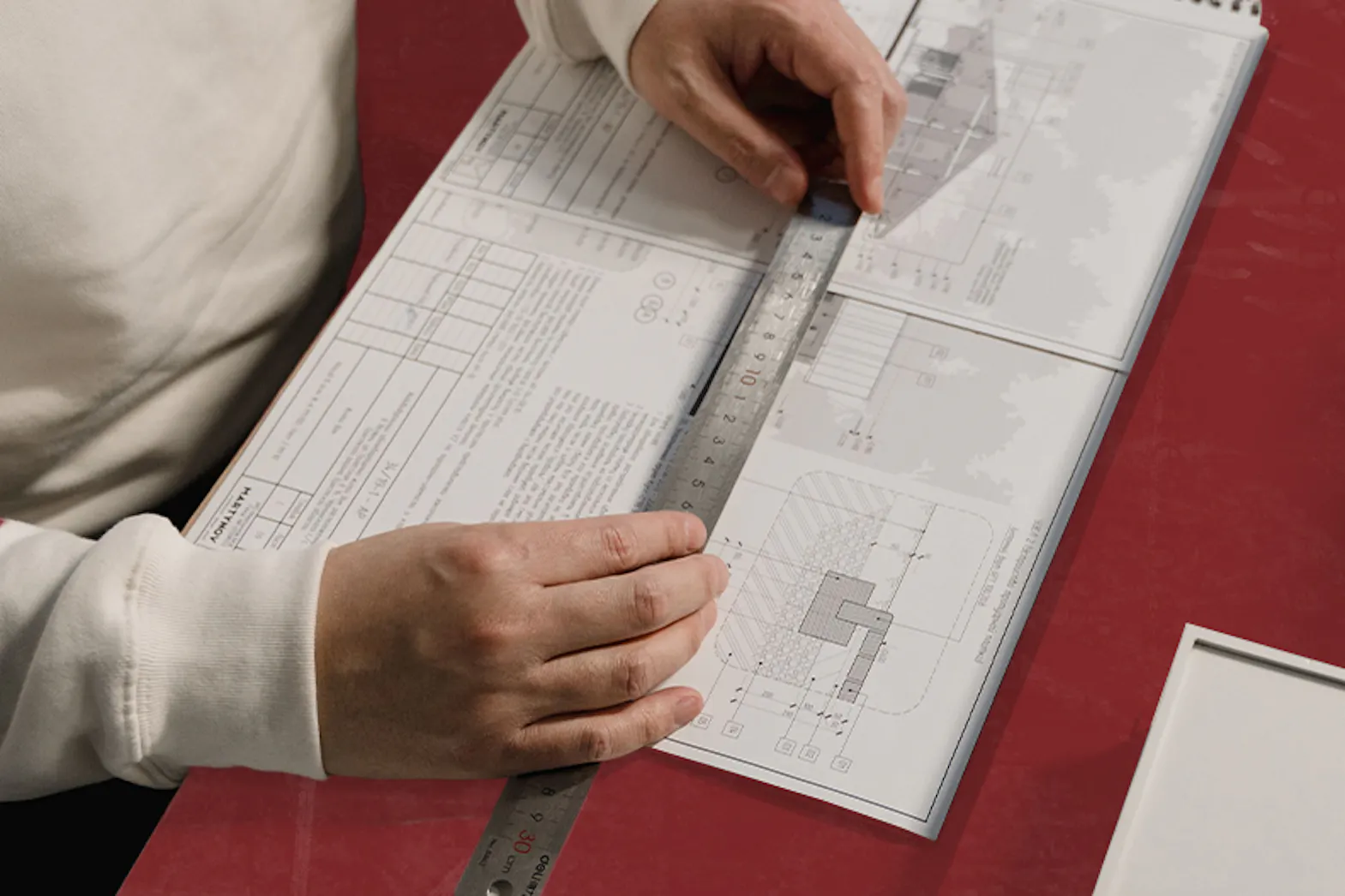 Person using a ruler to measure blueprints for a planning project