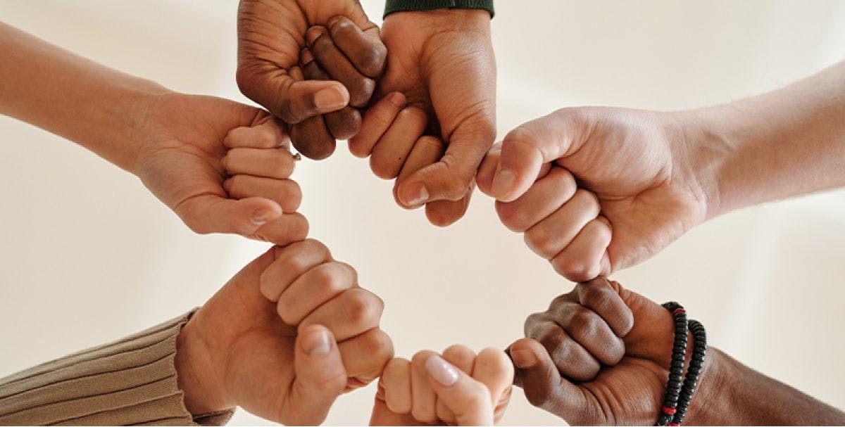 Close up of several hands fist bumping