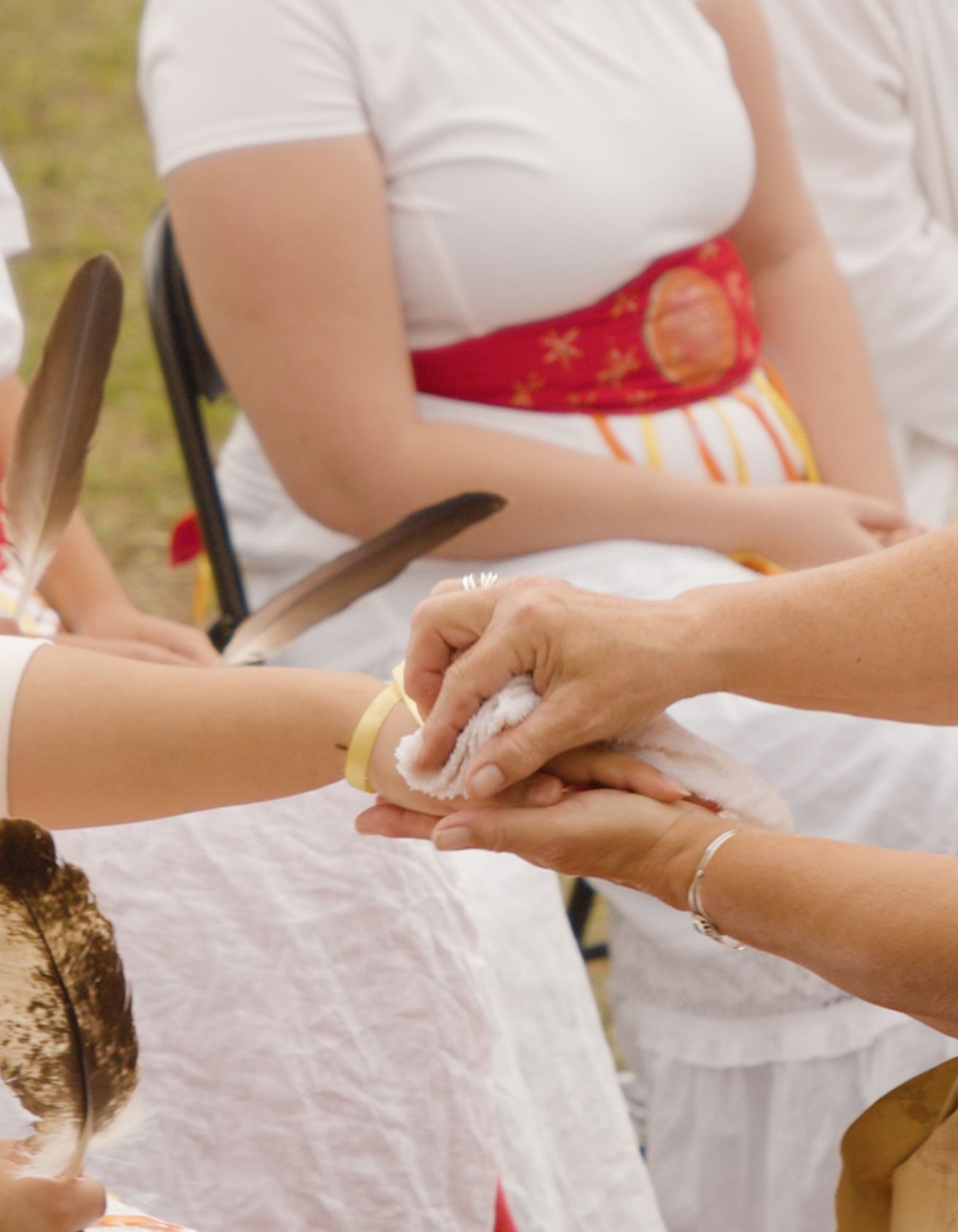 Two hands wiping another hand with a white towel