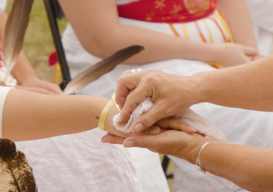 Two hands wiping another hand with a white towel