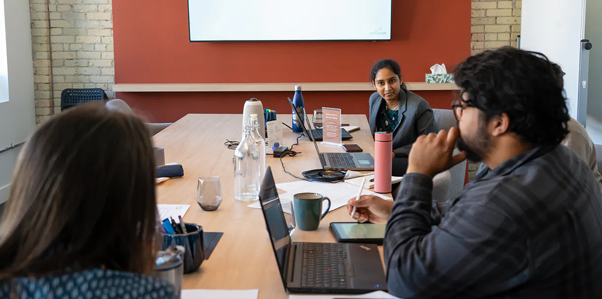 Narratives staff sitting at a board room table during ECO Canada training