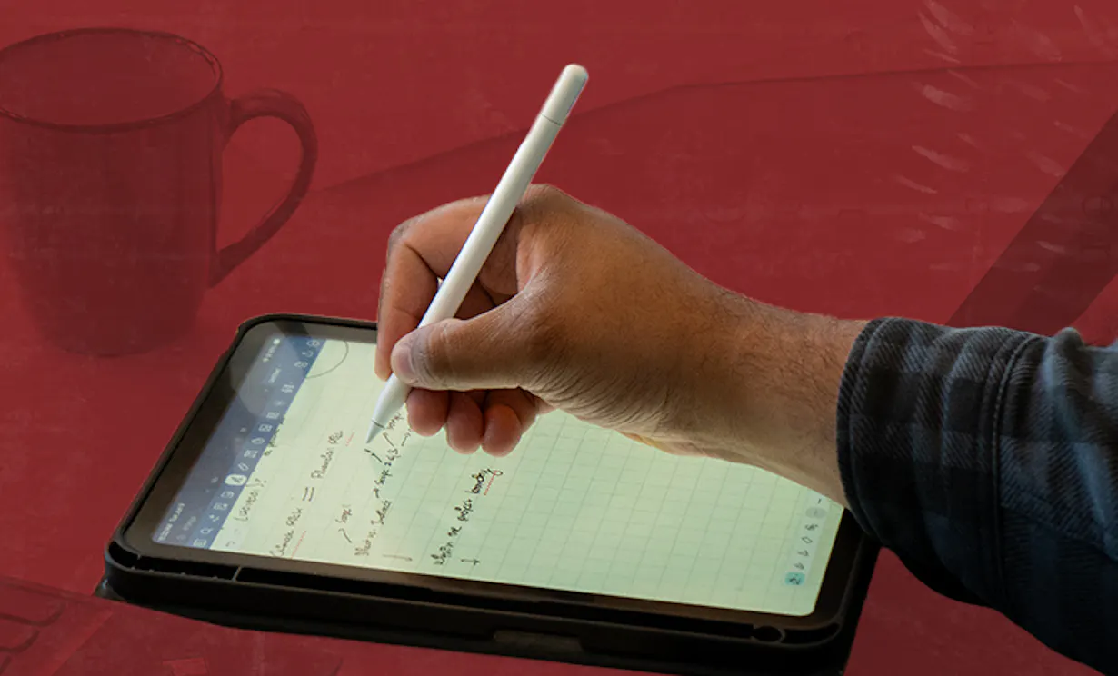 Hand writing notes on a tablet