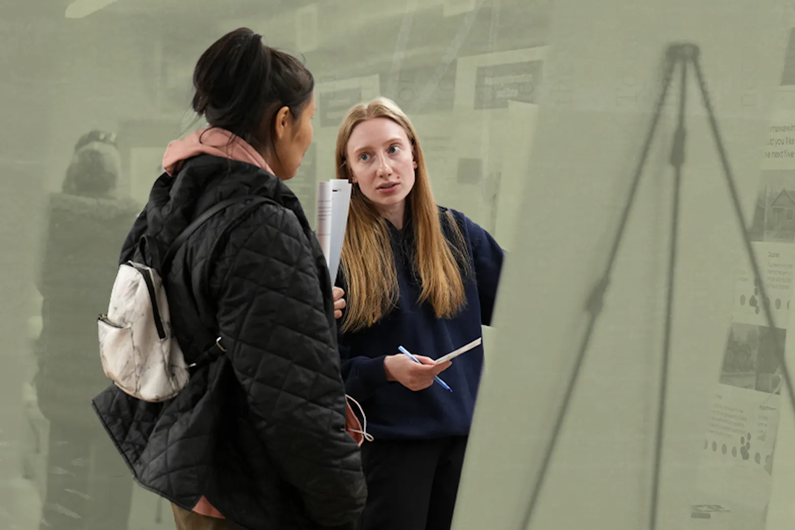 Two people talk in front of a climate action board at a community engagement