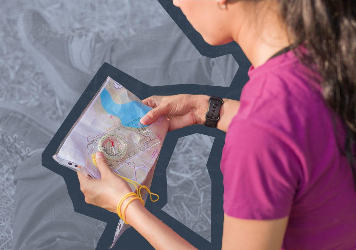 Woman reading a map and holding a compass.