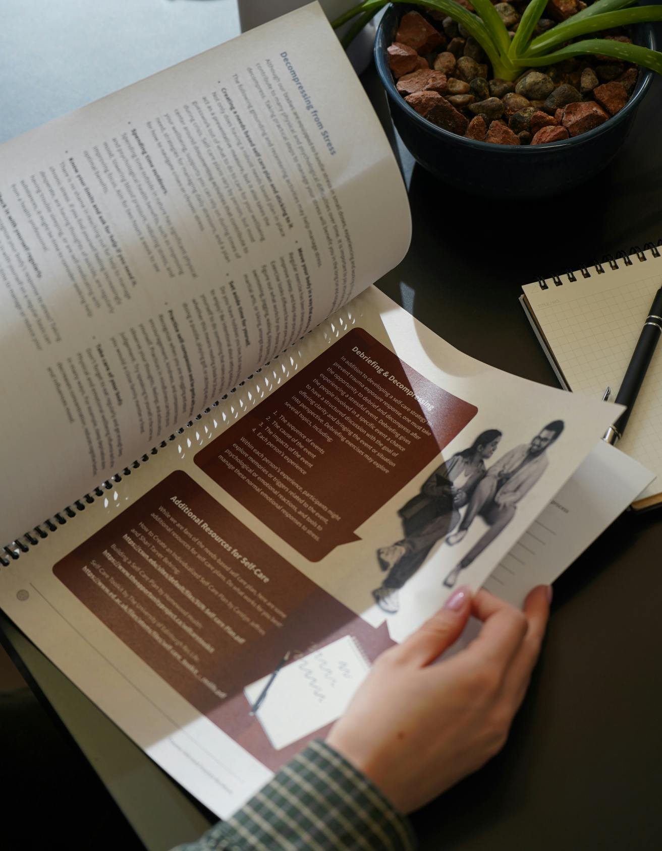 Close up of hand flipping through pages of a trauma-informed training handbook