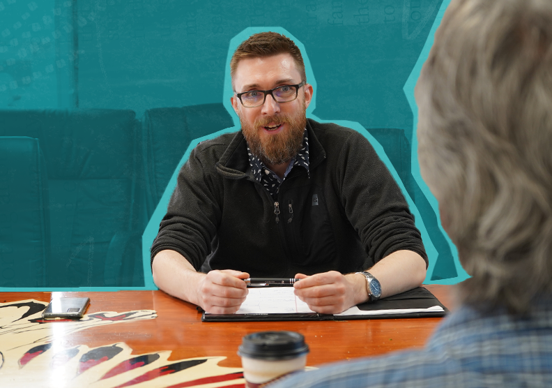 Man in glasses in discussion with colleague across table
