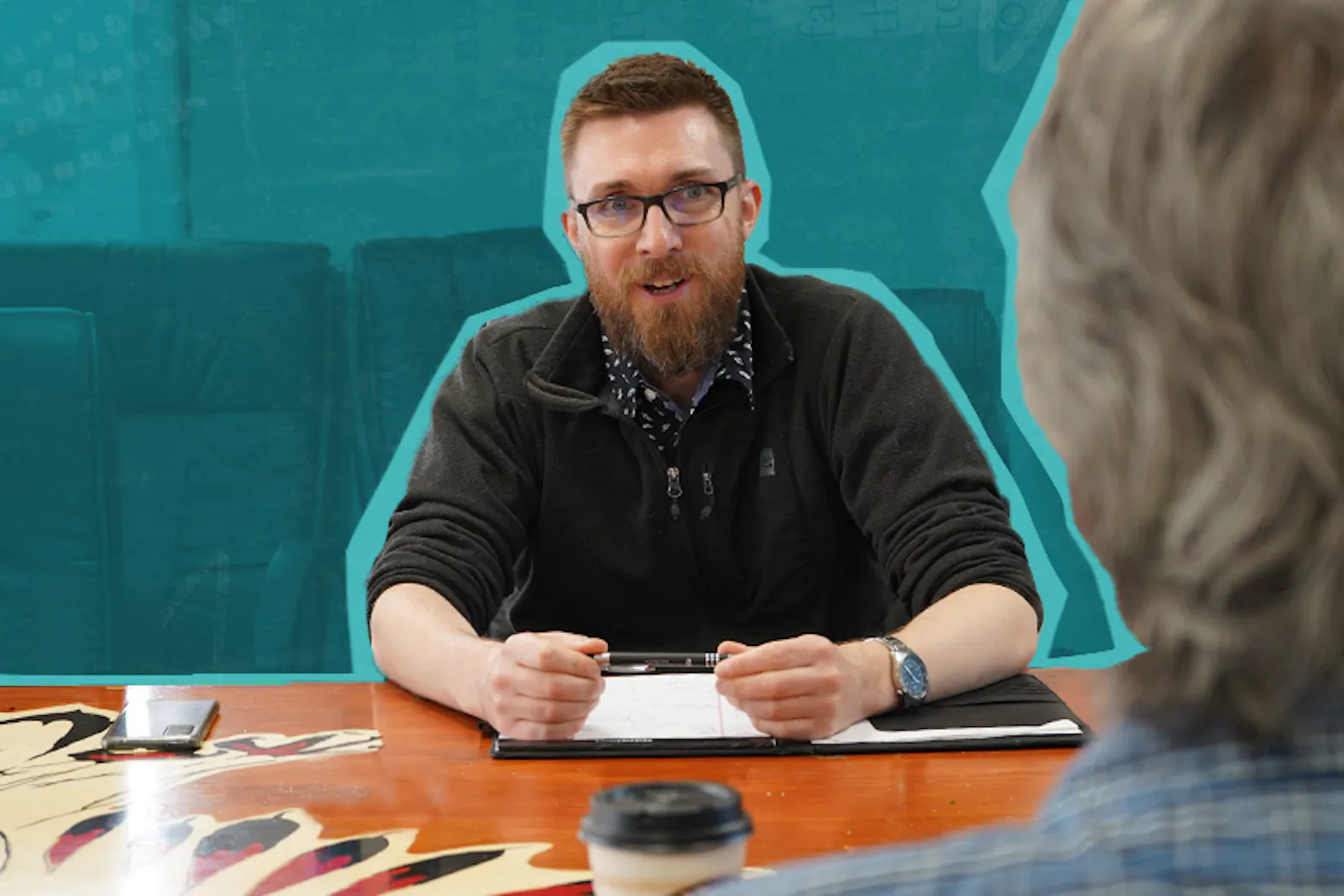Man in glasses in discussion with colleague across table