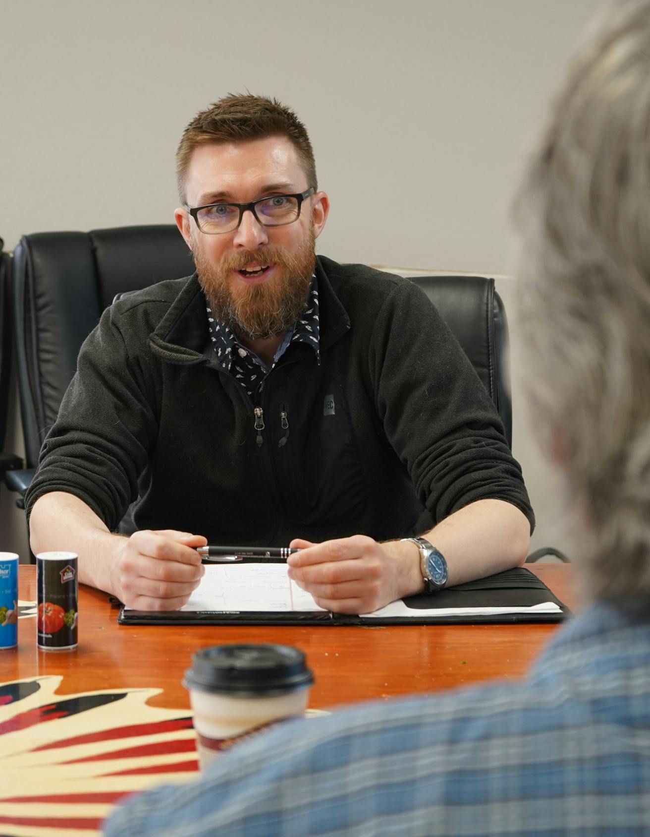 Man in glasses in discussion with colleague across table