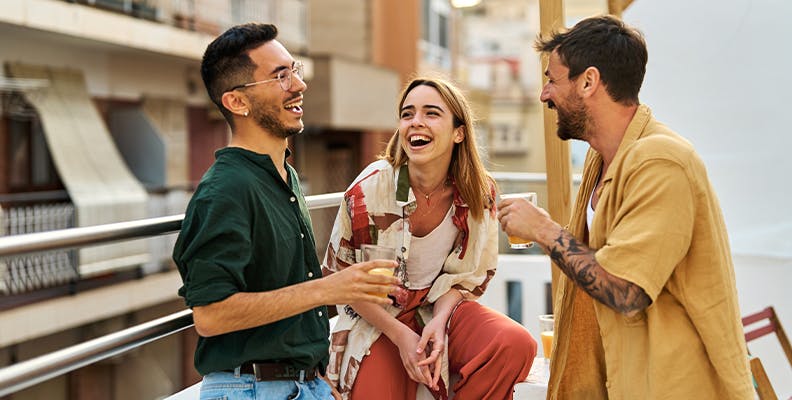 Young woman laughing with two male friends