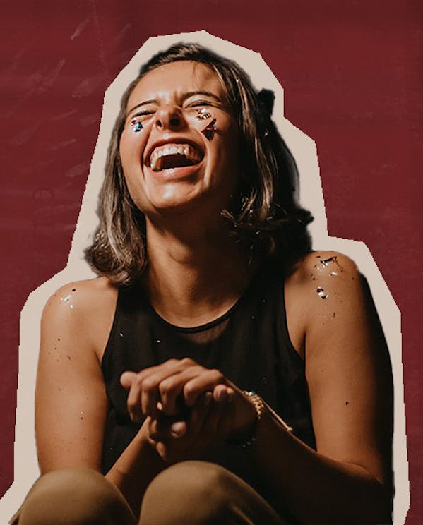 Young woman laughing with confetti on her face and arms
