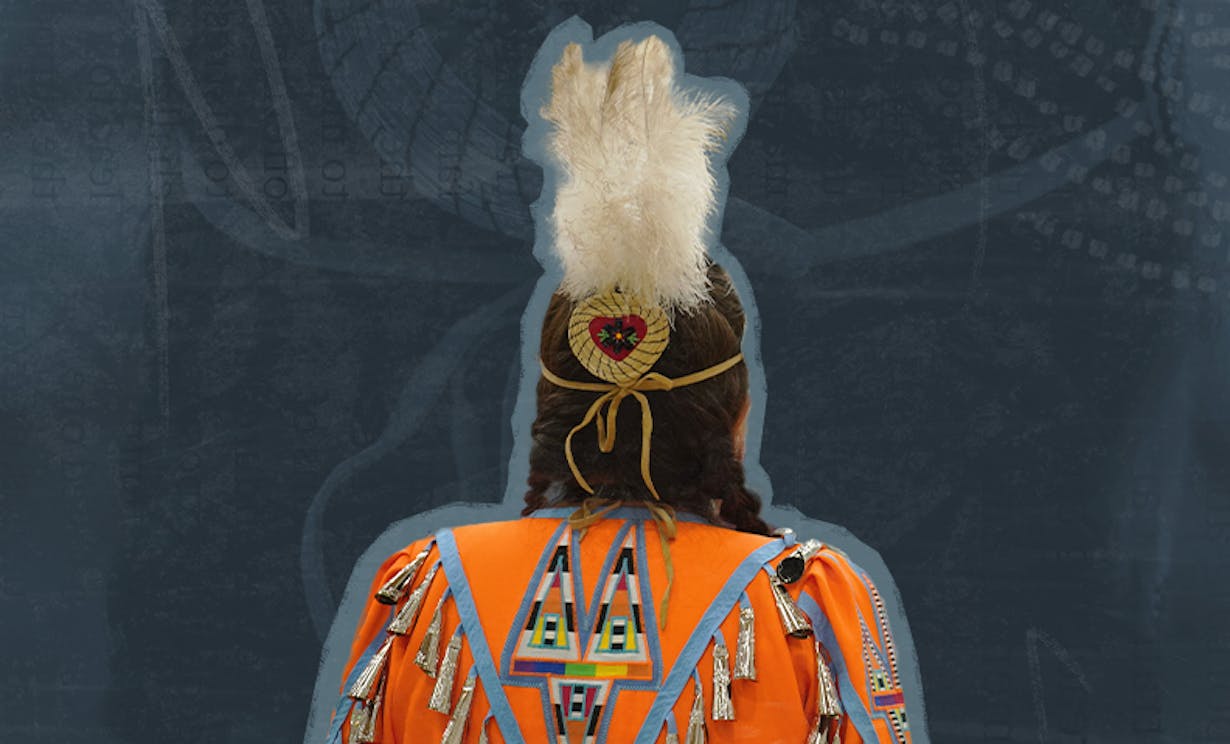 The back of a woman in customary Indigenous regalia with an orange jingle dress and three white feathers in her hair