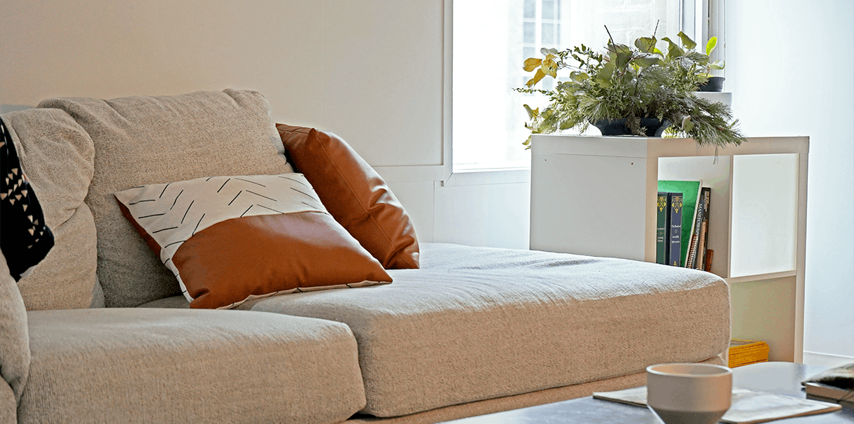 A comfortable couch with decorative pillows, in a welcoming space