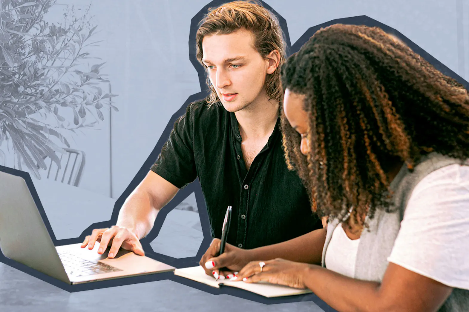 A man uses a laptop while a woman writes in a notebook beside him at a table