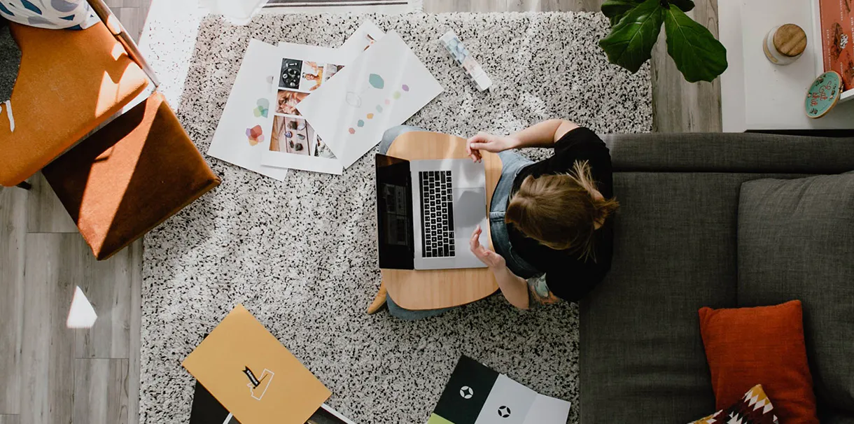 Overhead view of a woman working on her computer on the floor
