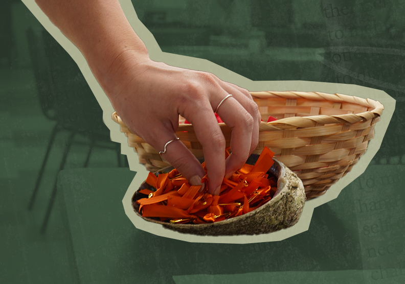 A hand reaches into a turtle shell full of orange ribbons