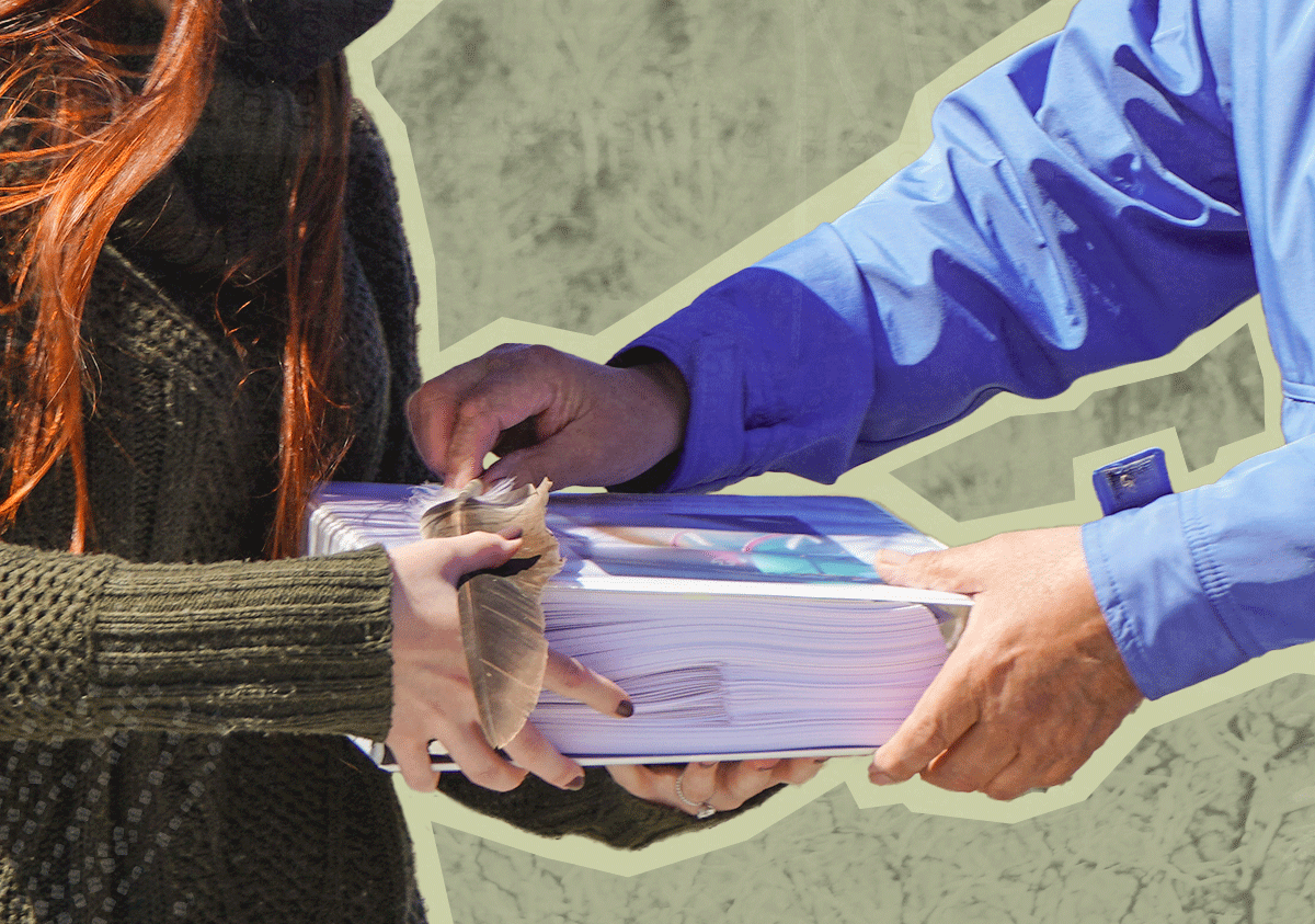People trading a large stack of booklets and a feather with each other