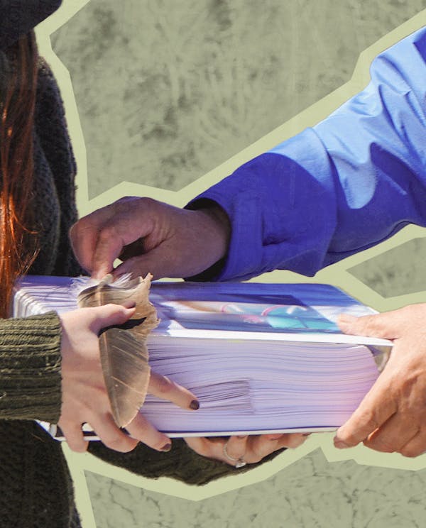 People trading a large stack of booklets and a feather with each other