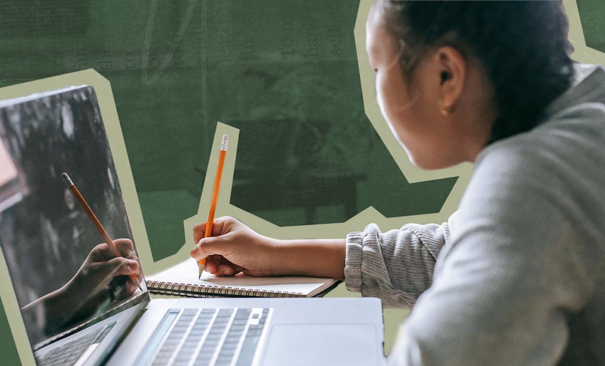 A woman writing on a notebook with a pencil. A laptop is sitting on the desk next to her
