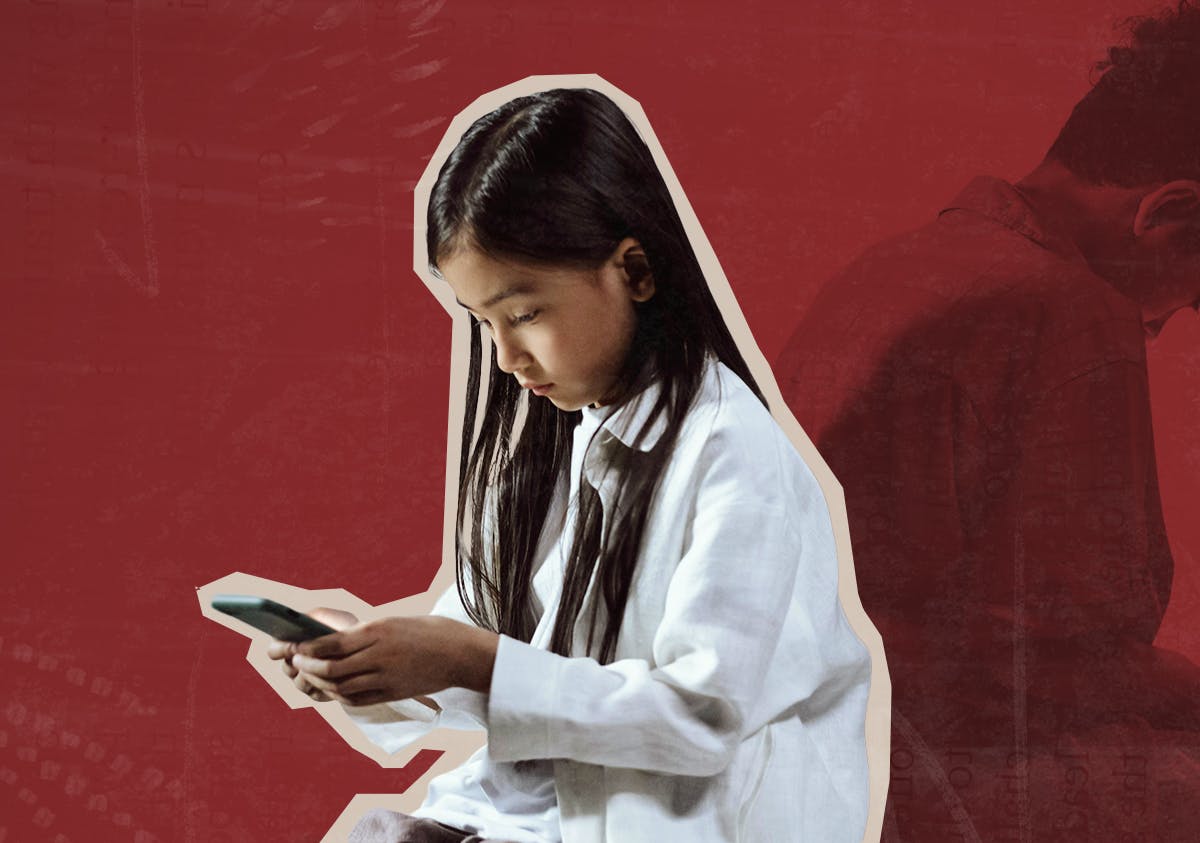 A young girl looks down at a phone screen