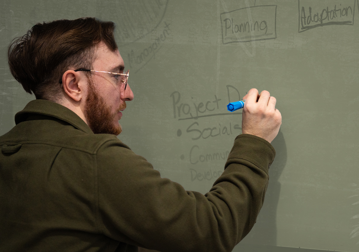 Brandon Klein writing on a whiteboard