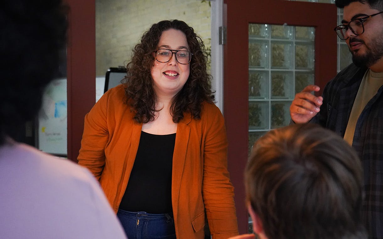 Alysha Oliver stands with staff in a boardroom