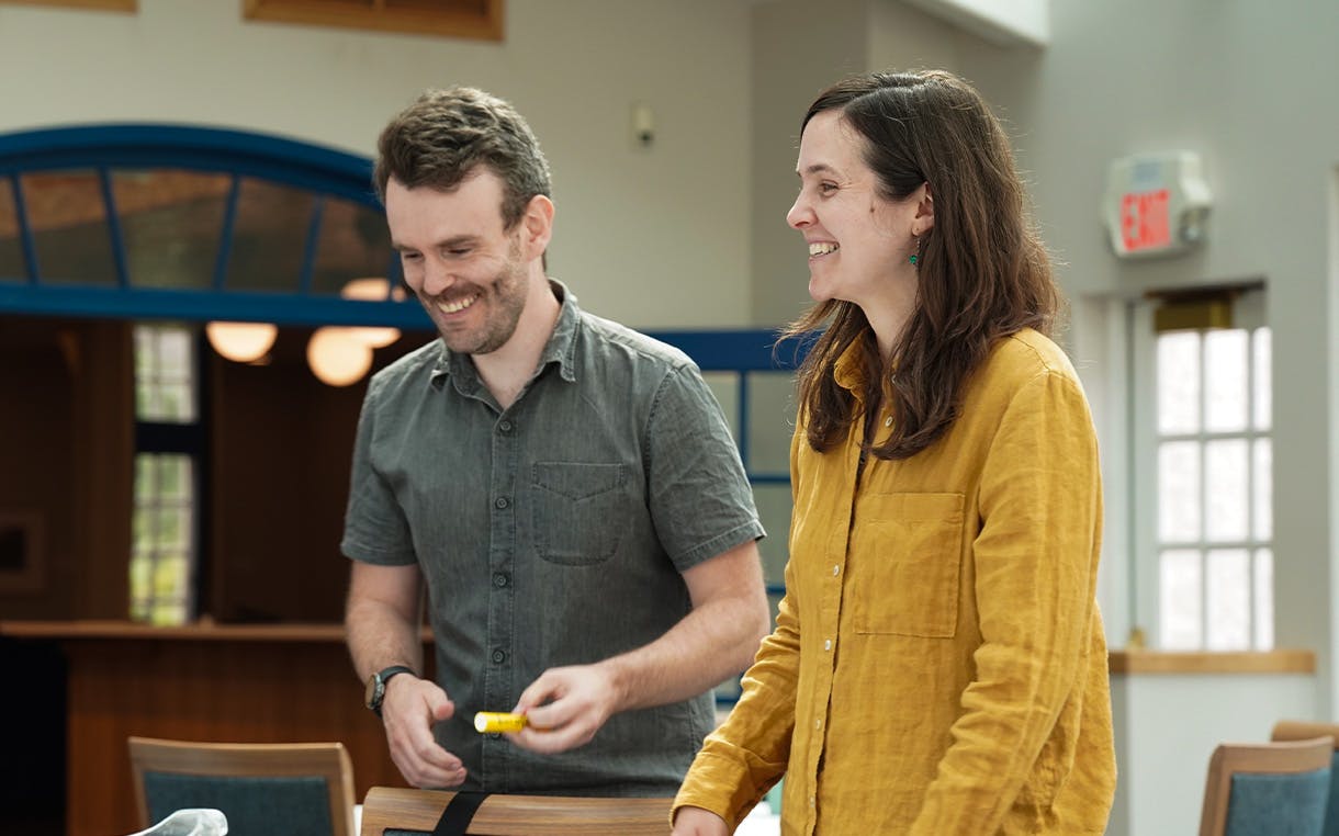 two people standing in a room smiling