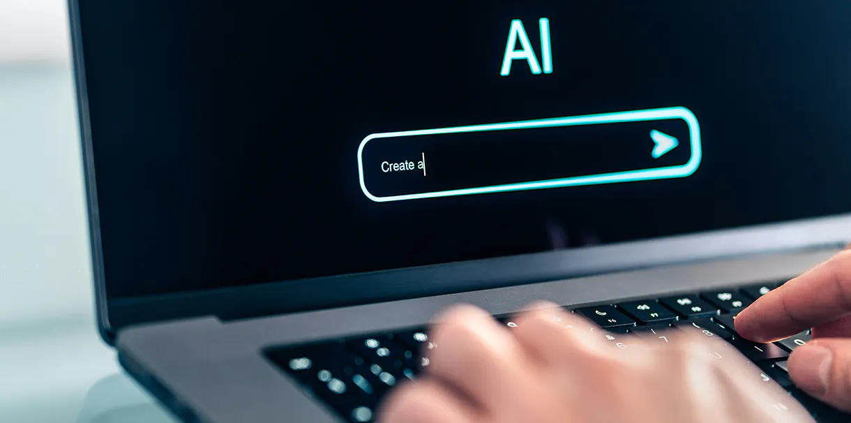 Hands typing on a computer. The screen shows an AI chat service.