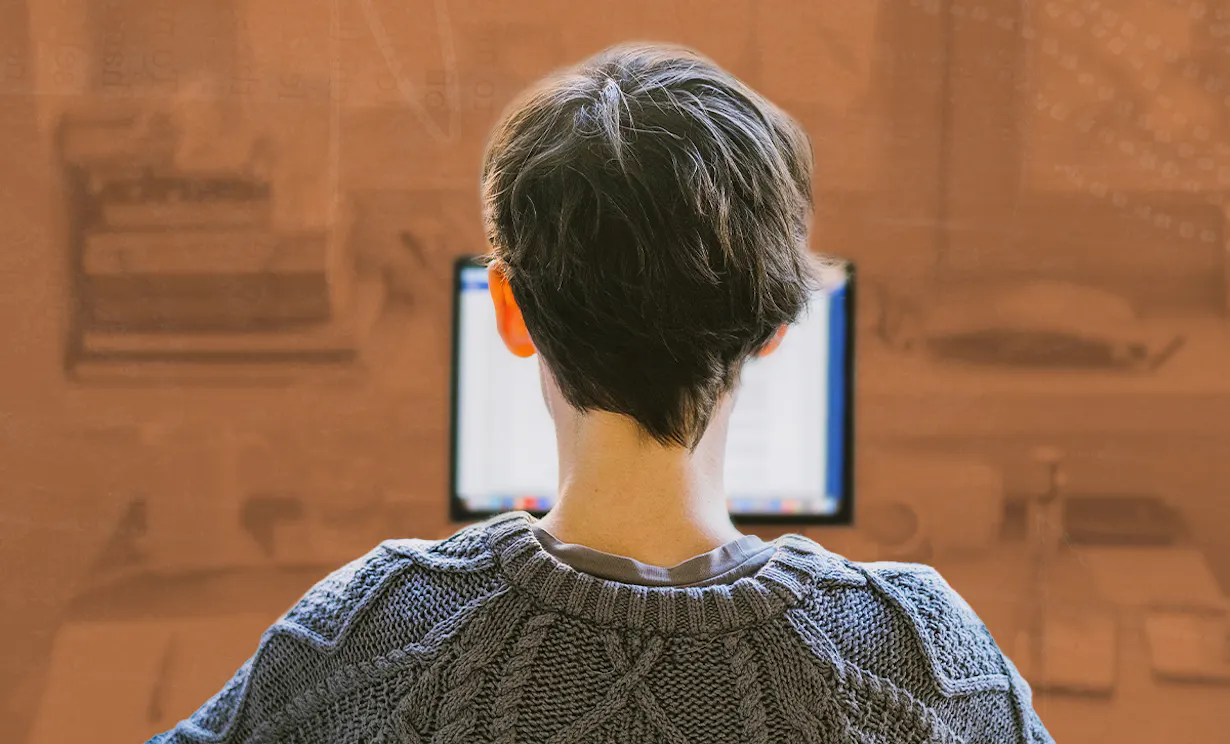 A woman working at her desk looking at her computer in her home office