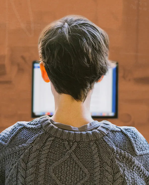 A woman working at her desk looking at her computer in her home office