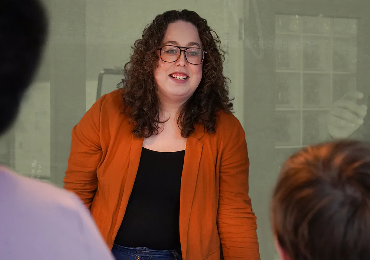 Alysha smiling at a group of people in a boardroom