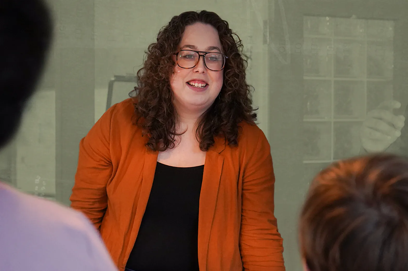 Alysha smiling at a group of people in a boardroom