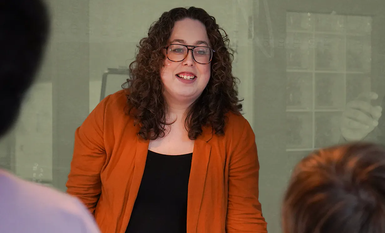 Alysha smiling at a group of people in a boardroom