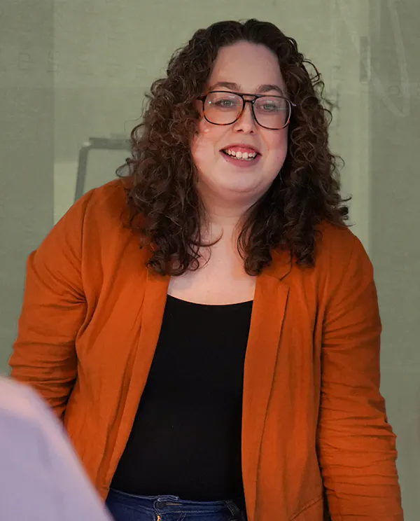 Alysha smiling at a group of people in a boardroom