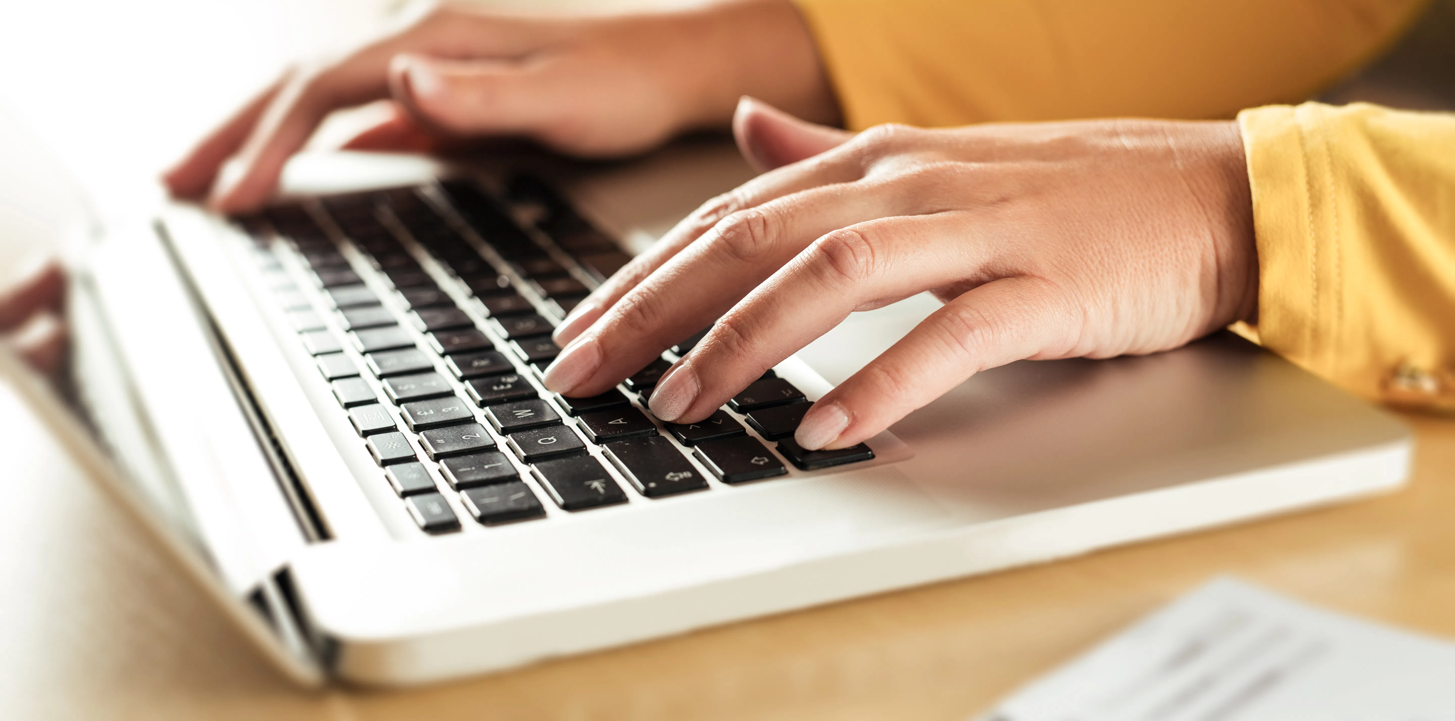 Hands typing on a laptop
