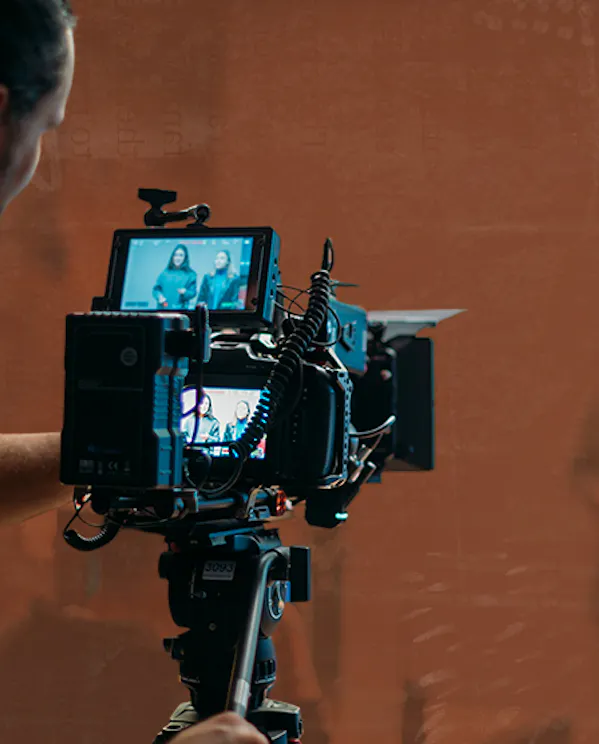 A man works behind a camera filming a video in a studio